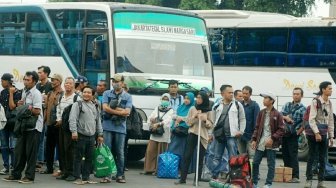 Sejumlah pemudik terlihat bergegas sementara sebagian lainnya menunggu bus di Terminal Kampung Rambutan, Jakarta, Sabtu (9/6/2018). [Suara.com/Oke Atmaja]