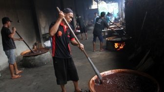 Pekerja membuat dodol Betawi di Kalibata, Jakarta, Selasa (12/6). 