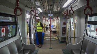 Pekerja beraktivitas di dalam gerbong Light Rail Transit (LRT) rute Kelapa Gading-Velodrome saat akan diuji coba di Kelapa Gading, Jakarta, Kamis (14/6).