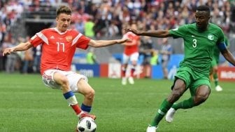 Pemain Rusia Aleksandr Golovin berebut bola dengan pemain Arab Saudi Alburayk di laga perdana Grup A Piala Dunia 2018, Kamis (14/6/2018) [AFP]