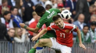 Pemain Rusia Aleksandr Golovin berebut bola dengan pemain Arab Saudi Alburayk di laga perdana Grup A Piala Dunia 2018, Kamis (14/6/2018) [AFP]