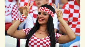 Seorang perempuan suporter timnas Kroasia memberi isyarat dua jari, jelang laga Grup D Piala Dunia 2018 antara Kroasia vs Nigeria di Stadion Kaliningrad, Rusia, Sabtu (16/6/2018). [Patrick HERTZOG / AFP]