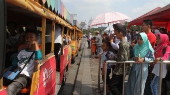 Sejumlah besar warga tampak memanfaatkan periode libur Idul Fitri 1439 H di area Monumen Nasional (Monas), Jakarta, Senin (18/6/2018). [Suara.com/Oke Atmaja]