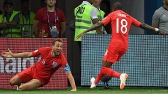 Bomber Inggris, Harry Kane (kiri) merayakan gol keduanya ke gawang Tunisia bersama Ashley Young (Mark RALSTON / AFP)