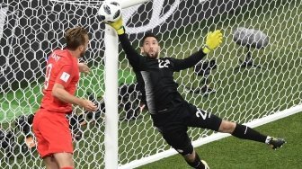 Penyerang andalan Timnas Inggris, Harry Kane (kiri) berjibaku dengan kiper Tunisia Mouez Hassen (NICOLAS ASFOURI / AFP)