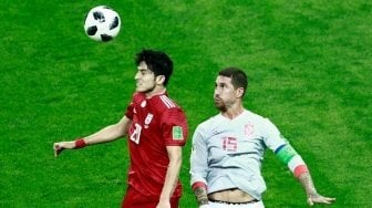 Penyerang Sardar Azmoun yang dijuluki Lionel Messi-nya Iran (kiri), melakukan duel udara dengan bek Spanyol Sergio Ramos (BENJAMIN CREMEL / AFP) 