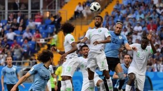 Pemain Uruguay dan Arab Saudi berebut bola di udara dalam pertandingan yang berlangsung di Rostov Arena, Rabu (20/6/2018) [AFP]