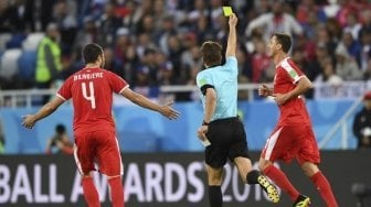 Gelandang Timnas Serbia, Nemanja Matic (kanan) diganjar kartu kuning oleh wasit di laga kontra Swiss (OZAN KOSE / AFP)