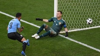 Pemain Uruguay Luis Suarez menjebol gawang Rusia yang dikawal Igor Akinfeev dalam pertandingan Grup A Piala Dunia 2018 yang digelar di Samara Arena, Senin (25/6/2018) [AFP]