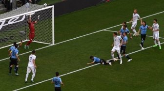 Penjaga gawang Rusia Igor Akinveef mematahkan peluang pemain Uruguay dalam pertandingan yang digelar di Samara Arena, Senin (25/6/2018) [AFP]