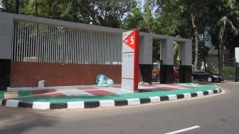 Warga melintas di pintu masuk kompleks Gelora Bung Karno (GBK), Jakarta, Selasa (26/6).