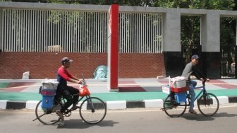 Warga melintas di pintu masuk kompleks Gelora Bung Karno (GBK), Jakarta, Selasa (26/6).