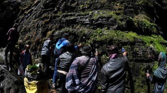 Masyarakat Suku Tengger menampung air yang menetes dari dinding goa ketika ritual pengambilan air suci dari mata air Widodaren di Gunung Widodaren, Probolinggo, Jawa Timur, Jumat (29/6).