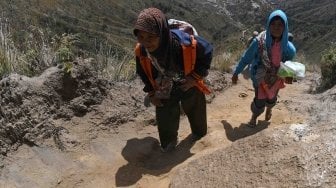 Masyarakat Suku Tengger mandaki Gunung Widodaren sambil membawa sesaji saat ritual pengambilan air suci di gunung tersebut di kawasan Gunung Bromo, Probolinggo, Jawa Timur, Jumat (29/6).