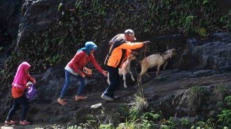 Masyarakat Suku Tengger membawa kambing yang akan dijadikan sesajen saat ritual pengambilan air suci di Gunung Widodaeren di kawasan Gunung Bromo, Probolinggo, Jawa Timur, Jumat (29/6).