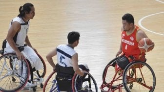 Pebasket kursi roda Indonesia Kasep Ayatollah (kanan) mencoba melewati pebasket Thailand Tawatchai Jiasin (kiri) dan Chaichana Kaewkaleong pada ajang Indonesia Para Games Invitational Tournament di Kompleks Gelora Bung Karno, Senayan, Jakarta, Senin (2/7).