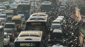 Suasana arus lalu lintas pada hari pertama uji coba perluasan kawasan ganjil genap di Jalan MT Haryono, Jakarta, Senin (2/7). 