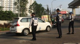 Suasana arus lalu lintas pada hari pertama uji coba perluasan kawasan ganjil genap di Jalan MT Haryono, Jakarta, Senin (2/7). 