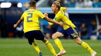 Fullback Timnas Swedia, Mikael Lustig merayakan gol Emil Forsberg (kanan) ke gawang Swiss (Anadolu Agency)