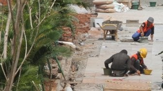 Sejumlah pekerja terlihat menyelesaikan proyek pembangunan dan penataan trotoar di Jalan Sudirman, Jakarta, Kamis (5/7/2018), menuju perhelatan Asian Games 2018. [Suara.com/Oke Atmaja]