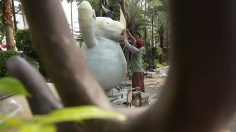 Para pekerja tampak menyelesaikan dan memasang maskot serta tulisan Asian Games 2018 di kawasan Balai Kota DKI, Jakarta, Kamis (5/7/2018). [Suara.com/Muhaimin A Untung]