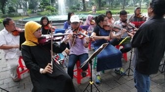 Belajar memainkan biola di Taman Menteng (Suara.com/Muhaimin A Untung)