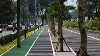 Suasana lalu lintas dan warga yang tampak berjalan di trotoar yang baru selesai direnovasi di Jalan Gerbang Pemuda Senayan, Jakarta, Selasa (10/7/2018). [Suara.com/Muhaimin A Untung]