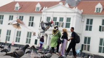 Meski belum bisa menjadi salah satu situs warisan dunia UNESCO, sejumlah pengunjung tampak beraktivitas di kawasan Kota Tua, Jakarta, Jumat (13/7/2018). [Suara.com/Oke Atmaja]