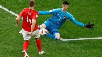 Gelandang Inggris, Eric Dier (kiri), men-chip bola melewati hadangan kiper Belgia, Thibaut Courtois, dalam perebutan peringkat ketiga Piala Dunia 2018 di Krestovsky Stadium, Saint-Petersburg, Sabtu (14/7). [Anadolu]