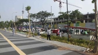 Pekerja Suku DInas Perindustrian dan Energi memperbaiki kabel perapian jaringan penerangan jalan umum di Pedestrian Kawasan Gelora Bung Karno (GBK), Jakarta, Selasa (17/7/2018).