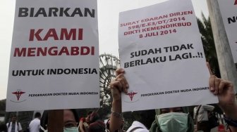 Ratusan orang yang tergabung dalam Pergerakan Dokter Muda Indonesia melakukan aksi di depan Taman Aspirasi Monas, Jakarta, Jumat (19/7). Dalam aksinya mereka meminta agar Kemeristekdi mengeluarkan ijazah Dokter yang disita.[suara.com/Muhaimin A Untung]
