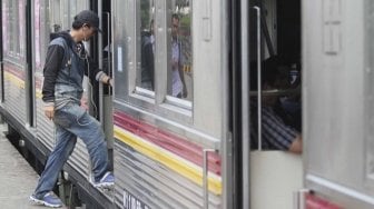 Penumpang masuk ke dalam gerbong di Stasiun Bogor, Kota Bogor, Jawa Barat, Senin (23/7). PT Kereta Commuter Indonesia (KCI) menyatakan transaksi tiket KRL di 79 stasiun mulai Senin (23/7) untuk sementara menggunakan tiket kertas seharga Rp3.000, sebagai bentuk mitigasi untuk kelancaran mobilitas pengguna KRL selama proses pembaharuan dan pemeliharaan sistem tiket elektronik. [Suara.com/Muhaimin A Untung]