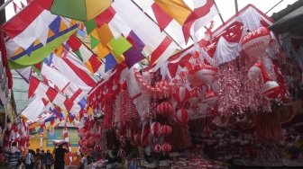 Penjual memajang bendera dan pernak-pernik bernuansa merah putih di Pasar Jatinegara, Jakarta, Senin (23/7). Bendera dan pernak-pernik yang dijual dengan harga Rp. 20 ribu hingga Rp. 500 ribu tergantung ukuran dan jenis bahan tersebut mulai marak dijual menjelang peringatan Hari Kemerdekaan Indonesia pada 17 Agustus. [Suara.com/Muhaimin A Untung]