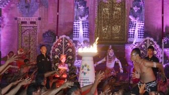 Legenda bulu tangkis Indonesia Susi Susanti  didampingi Kepala Istana Kepresidenan Tampaksiring I Dewa Gde Swarthana berlari membawa obor saat pawai obor (torch relay) Asian Games 2018 di Istana Kepresidenan Tampaksiring, Gianyar, Bali, Senin (23/7). Pawai Obor Asian Games 2018 di Pulau Dewata melintasi sejumlah lokasi antara lain Istana Kepresidenan Tampaksiring dan beberapa objek wisata di sejumlah kota/kabupaten. ANTARA FOTO/Fikri Yusuf