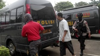 Pimpinan JAD Zainal Anshori alias Abu Fahry alias Qomaruddin bin M Ali dengan pengawalan petugas kepolisian bersiap mengikuti sidang perdana pembubaran Jamaah Ansharut Daulah (JAD) di Pengadilan Negeri Jakarta Selatan, Jakarta, Selasa (24/7). Dalam sidang tersebut, JAD didakwa sebagai kelompok yang menggerakan teror di Indonesia dan telah menyebabkan jatuhnya korban jiwa dan kerusakan objek vital. (Suara.com/ Muhaimin A Untung). 