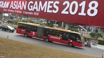 Bus Transjakarta melintas di sekitar Bunderan HI, Jakarta, Kamis (26/7). Wakil Gubernur DKI Jakarta Sandiaga Uno mengusulkan bus Transjakarta digratiskan diakhir pekan saat perhelatan Asian Games 2018  pada 18 Agustus hingga 2 September mendatang.  [suara.com/Muhaimin A Untung]