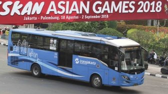 Bus Transjakarta melintas di sekitar Bunderan HI, Jakarta, Kamis (26/7). Wakil Gubernur DKI Jakarta Sandiaga Uno mengusulkan bus Transjakarta digratiskan diakhir pekan saat perhelatan Asian Games 2018  pada 18 Agustus hingga 2 September mendatang.  [suara.com/Muhaimin A Untung]