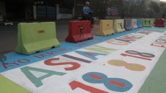 Pengendara melintas di Jalan Proklamasi yang telah dihiasi mural bertema  Asian Games, Jakarta Pusat, Jumat(27/7). Selain untuk menyambut Asian Games mural tersebut dibuat sebagai sosialisasi kepada masyarakat untuk mendukung perhelatan Asian Games 2018 Agustus mendatang