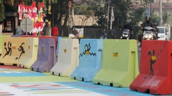 Pengendara melintas di Jalan Proklamasi yang telah dihiasi mural bertema  Asian Games, Jakarta Pusat, Jumat(27/7). Selain untuk menyambut Asian Games mural tersebut dibuat sebagai sosialisasi kepada masyarakat untuk mendukung perhelatan Asian Games 2018 Agustus mendatang