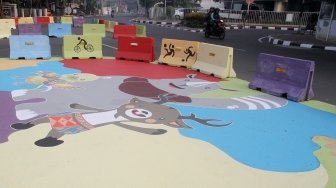 Pengendara melintas di Jalan Proklamasi yang telah dihiasi mural bertema  Asian Games, Jakarta Pusat, Jumat(27/7). Selain untuk menyambut Asian Games mural tersebut dibuat sebagai sosialisasi kepada masyarakat untuk mendukung perhelatan Asian Games 2018 Agustus mendatang