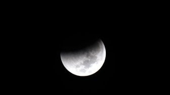 Gerhana bulan total atau "Blood Moon" terlihat dari kawasan Senayan, Jakarta, Sabtu (28/7) dini hari. Gerhana Bulan tersebut merupakan yang terlama pada abad ini dengan durasi sepanjang 103 menit dan seluruh proses gerhana sekitar 6,5 jam. [Oke Dwi Atmaja/Suara.com]