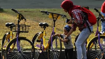 Pengunjung menggunakan sepeda dari layanan bike sharing di Monas, Jakarta, Jumat (27/7). Unit Pengelola Kawasan Monumen Nasional dan Unit Pengelola Jakarta menyediakan layanan bike sharing berbasis aplikasi, untuk para pengunjung yang ingin menjelajahi seluruh kawasan Monas ada 100 sepeda dari 7 titik. Layanan itu merupakan kerja sama antara Smart City dan GOWES selaku operator bike sharing. [suara.com/Muhaimin A Untung]