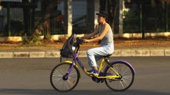 Pengunjung menggunakan sepeda dari layanan bike sharing di Monas, Jakarta, Jumat (27/7). Unit Pengelola Kawasan Monumen Nasional dan Unit Pengelola Jakarta menyediakan layanan bike sharing berbasis aplikasi, untuk para pengunjung yang ingin menjelajahi seluruh kawasan Monas ada 100 sepeda dari 7 titik. Layanan itu merupakan kerja sama antara Smart City dan GOWES selaku operator bike sharing. [suara.com/Muhaimin A Untung]