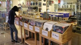 Pengunjung memilih piringan hitam di sebuah toko musik Paper Pot Record di kawasan Blok M, Jakarta, Minggu (29/7). Toko tersebut mengobral koleksi piringan hitam yang diproduksi pada tahun 1950-an dengan harga Rp75 ribu hingga Rp200 ribu per keping, totalnya dengan koleksi sekitar 10.000 pirangan hitam. [Suara.com/Oke Dwi Atmaja]