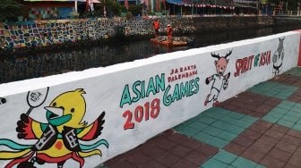 Aktivitas warga di Kampung Tematik, Kemayoran, Jakarta, Minggu (29/7). Dalam rangka menyambut Asian Games 2018, Pemprov DKI Jakarta bekerjasama dengan AkzoNobel melakukan pengecatan untuk mempercantik lingkungan di sekitar wisma atlet. [Suara.com/Oke Dwi Atmaja]