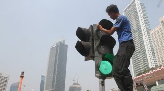 Pejalan kaki sedang menyebrang di pelican crossing dikawasan Thamrin, Jakarta, Senin (30/7). Pelican crossing dikawasan Thamrin sudah bisa di gunakan sebagai pengganti JPO yang akan dibongkar. [Suara.com/Oke Dwi Atmaja]