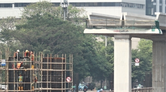 Pekerja menyelesaikan proyek light rail transit atau LRT yang melintas di Jl Rasuna Said, Jakarta, Selasa (31/7). Kereta ringan Jabodebek ditargetkan beroperasi pada Mei 2019 yang bakal melintasi tiga rute atau lintasan, yakni dari Cibubur menuju Cawang, Bekasi Timur menuju Cawang, dan Cawang menuju Dukuh  Atas belum dapat dipakai saat perhelatan akbar Asian Games. [suara.com/Muhaimin A Untung].