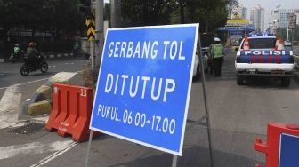 Dirlantas Polda Metro Jaya bersama Dinas Perhubungan DKI Jakarta menjaga pintu gerbang tol yang ditutup di Tol Slipi 2, Jakarta, Rabu (1/8). Penutupan pintu tol secara permanen di 19 pintu tol tersebut demi kelancaran transportasi penyelenggaraan Asian Games 2018 agar waktu tempuh perjalanan atlet dari wisma atlet menuju veneu cuma 30 menit. [suara.com/Muhaimin A Untung].