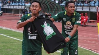 Dua pemain Persebaya, Rendi Irwan dan Oktaviano Fernando membetangkan kaus bergambar Angel Alfredo Vera sebagai penghormatan [Suara.com / Dimas ANGGA]