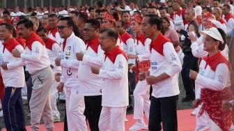 Presiden Joko Widodo bersama Wakil Presiden Jusuf Kalla melakukan senam poco-poco saat pemecahan rekor dunia Guinness World Records  di Monas, Jakarta, Minggu (5/8). Kegiatan tersebut dalam rangka menyambut Asian Games 2018 itu diikuti 65 ribu peserta dari berbagai kalangan. [suara.com/Muhaimin A Untung]